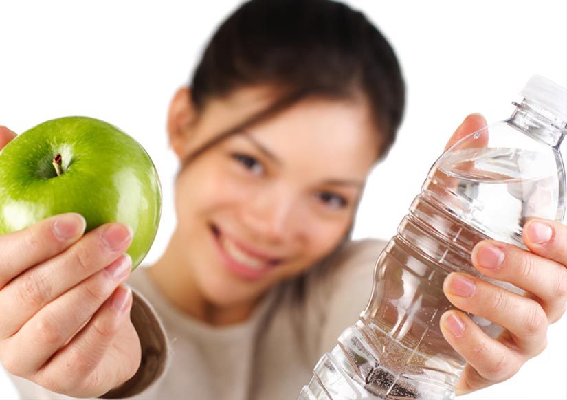 Woman with apple and water for weightloss